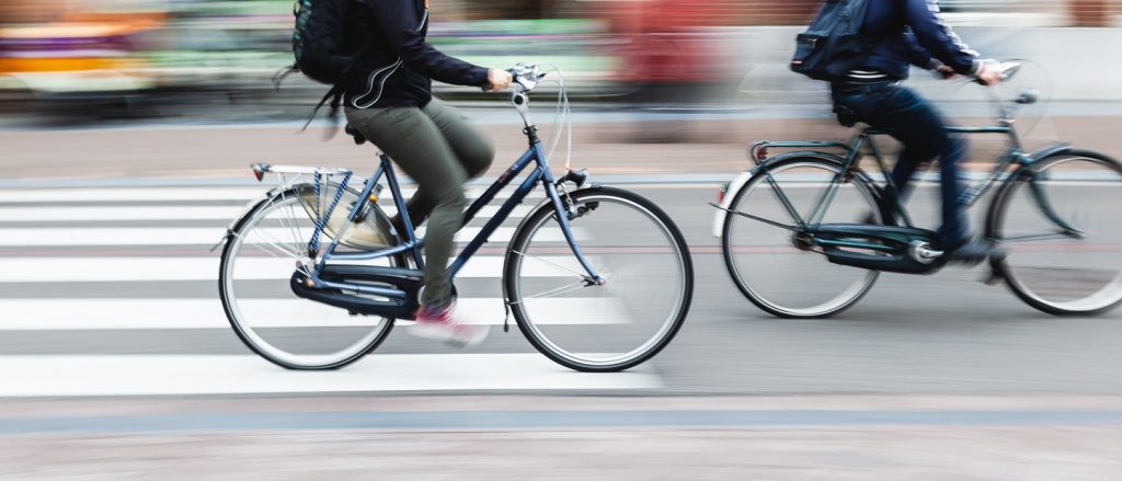 Fahrräder in der Stadt überfahren einen Fußgängerüberweg.