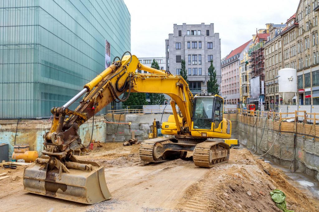 Ein Bagger steht auf einer Baustelle in der Stadt.