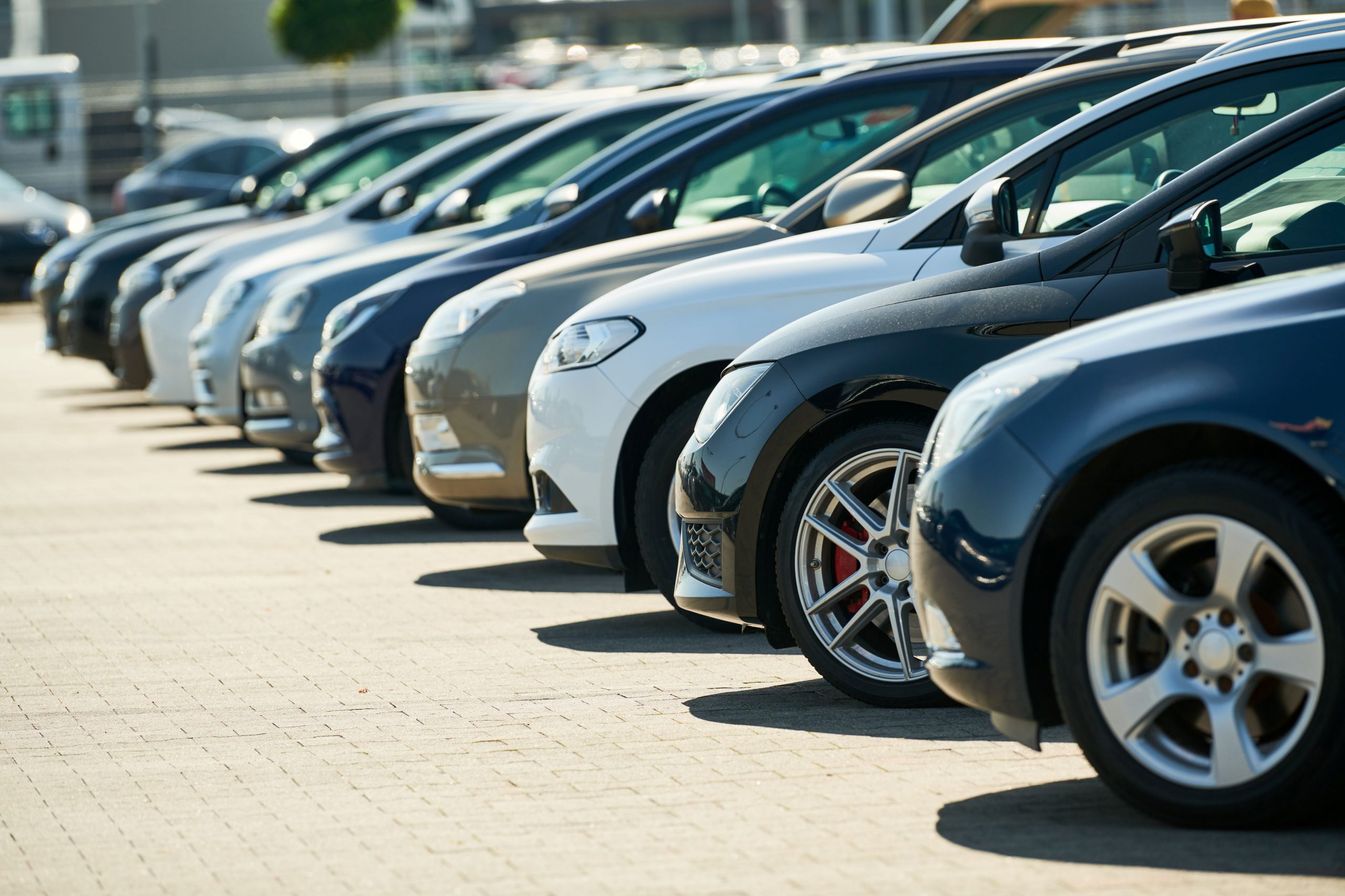 Mehrere Autos stehen nebeneinander auf dem Hof eines Autohauses.